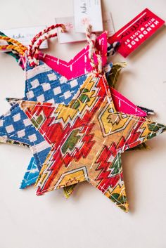 an ornament made out of colorful fabric with tags attached to the top and bottom