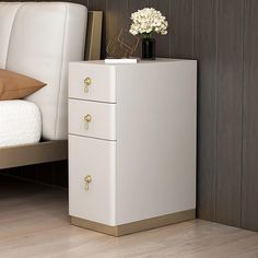 a white and gold nightstand next to a bed