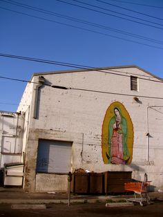 an old white building with a painting on the side