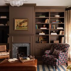 a living room filled with furniture and a fire place in front of a book shelf