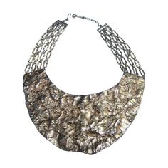 Massive hammered gilt metal collar necklace c 1970 The avant-garde statement necklace is designed with a modernist style large scale crescent plate The center hammered plate is substantial in weight; is suspended for a series of wide gilt link chains The bold large scale design makes a very striking accessory Surprisingly the necklace is unsigned has the design & quality of a high end designer creation Measurements The necklace necklace following the interior curve of the design measures 17" inc Ethereal Dramatic, Metal Collar, Avant Garde Jewelry, Necklace C, Gold Collar Necklace, Metal Spikes, Diamond Decorations, Spike Necklace, Scale Design