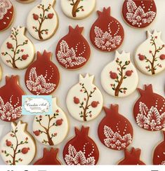 decorated cookies with pomegranates and leaves are displayed on a white surface