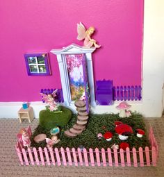 there is a doll house with pink walls and green grass on the ground in front of it