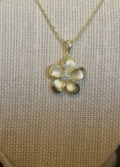 .925 Sterling silver with 14K Yellow Gold overlay Hawaiian Plumeria Pua Melia 3-stone Past, Present and Future Necklace. Designed to mimic the look of fine jewelry at a fraction of the cost. -- The size is 22MM, a bit under quarter size. FREE Italian Sterling Silver beaded chain included your choice of length. It has a Sandblasted Matte center with High-Polished shiny edges and three Cubic zirconias in the Flowers center for added sparkle. -- The Plumeria is sacred in Hawaiian culture and is oft Fine Jewelry Flower Pendant With Polished Finish, Fine Jewelry White Gold Flower Pendant, Dainty White Jewelry With Polished Finish, Delicate White Gold Jewelry With Polished Finish, White Gold Flower Shaped Jewelry For Anniversary, Delicate Engraved White Gold Jewelry, Elegant Flower Pendant Jewelry With Polished Finish, Flower Shape Jewelry As A Gift With Polished Finish, Formal Jewelry With Polished Flower Pendant