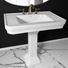 a white sink sitting under a mirror on top of a bathroom counter next to a black wall