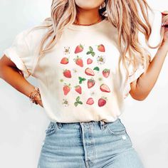 Cute Strawberry Shirt 🍓 IMPORTANT INFORMATION This t-shirt is really soft and comfortable to wear. You will love it!  You can tuck or tie a knot at the bottom for a stylish put together look.  Wear it which ever way you want. 🙂 MATERIALS/FABRIC  Solid Colors: 100% combed and ring spun cotton, 30 single, 4.2 oz.  The double-needle stitching throughout the tee makes it highly durable  while the lack of side-seams helps the shirt retain its tubular shape. SIZING AND COLOURS  You will find the siz Casual Short Sleeve Tops With Strawberry Print, Casual White Top With Strawberry Print, Trendy Strawberry Print Cotton Shirt, Strawberry Print Cotton Crew Neck Top, Cotton Crew Neck Top With Strawberry Print, Trendy Cotton Shirt With Strawberry Print, Cotton Shirt With Strawberry Print For Spring, Strawberry Print Cotton Graphic Tee, Cotton Strawberry Print Graphic Tee