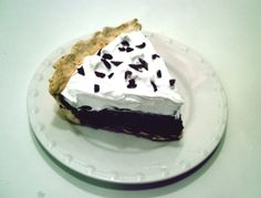 a piece of pie on a plate with whipped cream and chocolate sprinkles