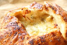 a close up of a baked bread with cheese and herbs on it's crust