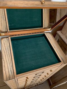 an open wooden box with green felt inside