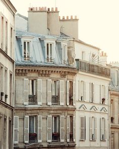 an old building with white shutters and balconies on the top floor in paris