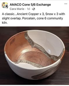 a white and brown bowl sitting on top of a wooden table