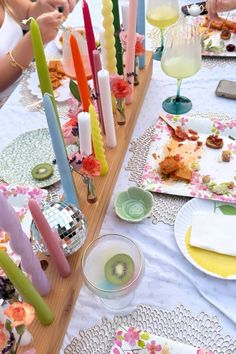 the table is set with colorful candles and plates