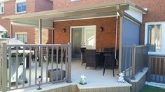 an outdoor patio with chairs and table next to brick building