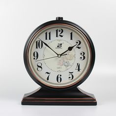 a black and gold clock is on a white background with the numbers five to twelve