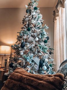 a white christmas tree with blue and silver ornaments