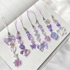 a bunch of necklaces sitting on top of a white table next to a notebook