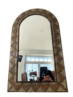 a woman taking a selfie in front of a mirror with a drum on it