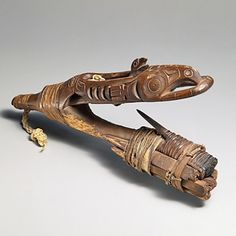 an old wooden object that looks like it has been carved into the shape of a lizard