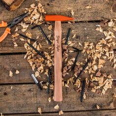 an assortment of wood shavings and hammers on a wooden table with tools