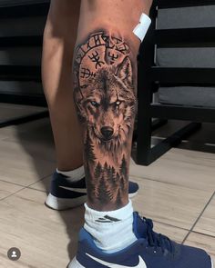 a man's leg with a wolf tattoo on it