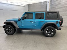 a blue jeep is parked in a garage