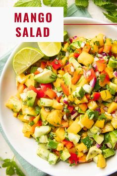 mango salad in a white bowl with limes and cilantro on the side