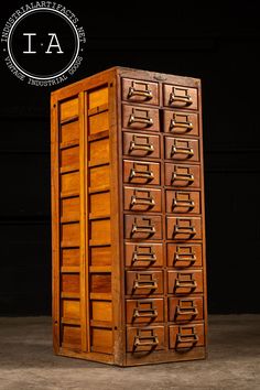 an old wooden filing cabinet with many drawers on the top and bottom, in front of a black background