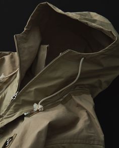 This cold-weather parka is a cross between a 1940s British smock and the design and specifications of an American mountain parka, developed in a unique interpretation. The fabric was commissioned to the first factory in Japan to be certified as an official producer of military uniform fabrics. Egyptian Giza cotton is used and woven to the highest possible density to provide water repellency. Brown Utility Parka For Outdoor, Brown Parka With Detachable Hood For Outdoor Activities, Brown Outdoor Parka With Adjustable Hood, Brown Parka With Adjustable Hood For Outdoor, Beige Hooded Parka With Drawstring Hood, Beige Parka With Pockets For Outdoor, Khaki Techwear Windbreaker With Double-lined Hood, Khaki Parka With Drawstring Hood For Outdoor Activities, Hooded Khaki Parka For Hiking