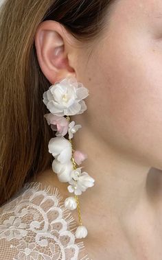 a close up of a person wearing earrings with flowers on them