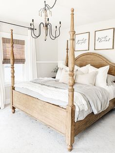 a bedroom with a bed, chandelier and window in the corner is shown