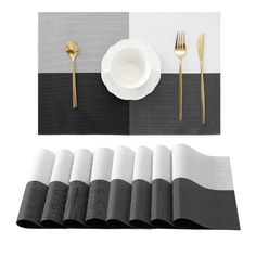 a place setting with black and white napkins, silverware and gold - plated utensils