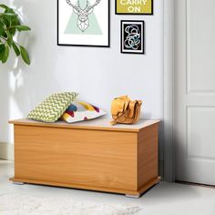 a wooden bench in front of a white wall with pictures on the wall and a purse next to it