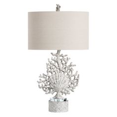 a table lamp with a white shade on the base and a light fixture in the shape of a coral