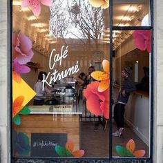 the front window of a cafe with flowers painted on it