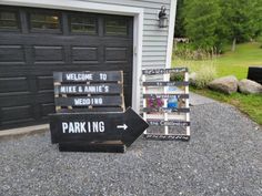 two wooden signs sitting on top of gravel next to a garage