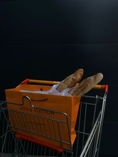 two loaves of bread sit in a shopping cart with the handles down and on