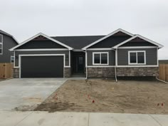 a gray house with two garages in the front and one on the other side