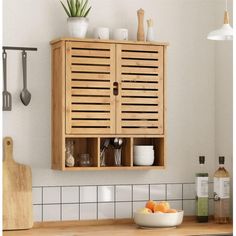 a wooden cabinet sitting on top of a kitchen counter next to a bowl of fruit