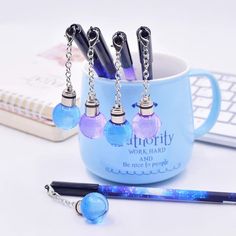 a blue mug with six key chains hanging from it