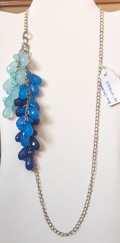 "This silver curb chain has 3 tiers of 3 different blue teardrop acrylic beads cascading down off the chain.  It makes for an interesting waterfall effect.  The colors of blue go from light to a dark blue.  Lots of different ways you can wear this necklace.  I like it all off to one side for a different look.  The necklace measures 26\" in length and does not have a clasp." Blue Teardrop Necklace With Adjustable Chain, Handmade Blue Necklaces With Long Drop Shape, Handmade Blue Long Drop Necklace, Handmade Blue Necklace With Long Drop, Adjustable Blue Teardrop Drop Necklace, Adjustable Teardrop Blue Drop Necklace, Handmade Blue Teardrop Pendant Drop Necklace, Handmade Blue Teardrop Drop Necklace, Blue Briolette Drop Necklace