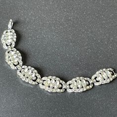 Beautiful vintage Art Deco style paste cocktail bracelet with a gorgeous geometric design with lots of rhinestones. It has wide panels with a romantic Deco design which is really luxurious and quite unusual. Each of the panels is encrusted with rhinestones, including marquise/navette cut stones, and has pierced metal work in lovely geometric lines. The bracelet has a length of 7.5 inches and fastens with a secure hinged fold-over clasp. It is in very good vintage condition for its age - all rhin Art Deco Silver Bracelets With Diamond Accents, Silver Art Deco Marquise-cut Jewelry, Vintage Silver Marquise-shaped Jewelry, Silver Art Deco Diamond Cut Bracelet, Adjustable Silver Art Deco Bracelets, Cocktail Bracelet, Cocktail Vintage, Art Deco Bracelet, Geometric Lines