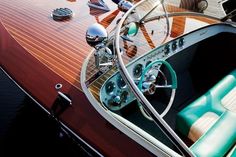 the inside of a boat with steering wheel and seats