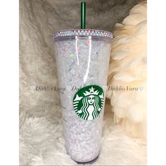 the starbucks cup is decorated with glitter and has a green straw sticking out of it