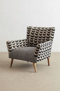 a black and white patterned chair with wooden legs