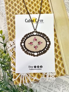 a card with an embroidered pendant on it