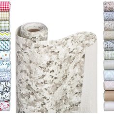 a roll of cloth next to several rolls of fabric on a white background with different patterns and colors