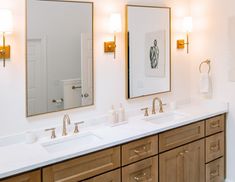 a bathroom with double sinks and two mirrors on the wall next to eachother