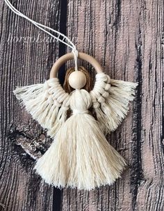 an angel ornament hanging from a string on a wooden surface with other decorations