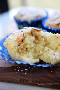 two muffins sitting on top of a blue plate next to a wooden cutting board