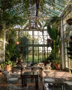 the inside of a greenhouse with tables and chairs